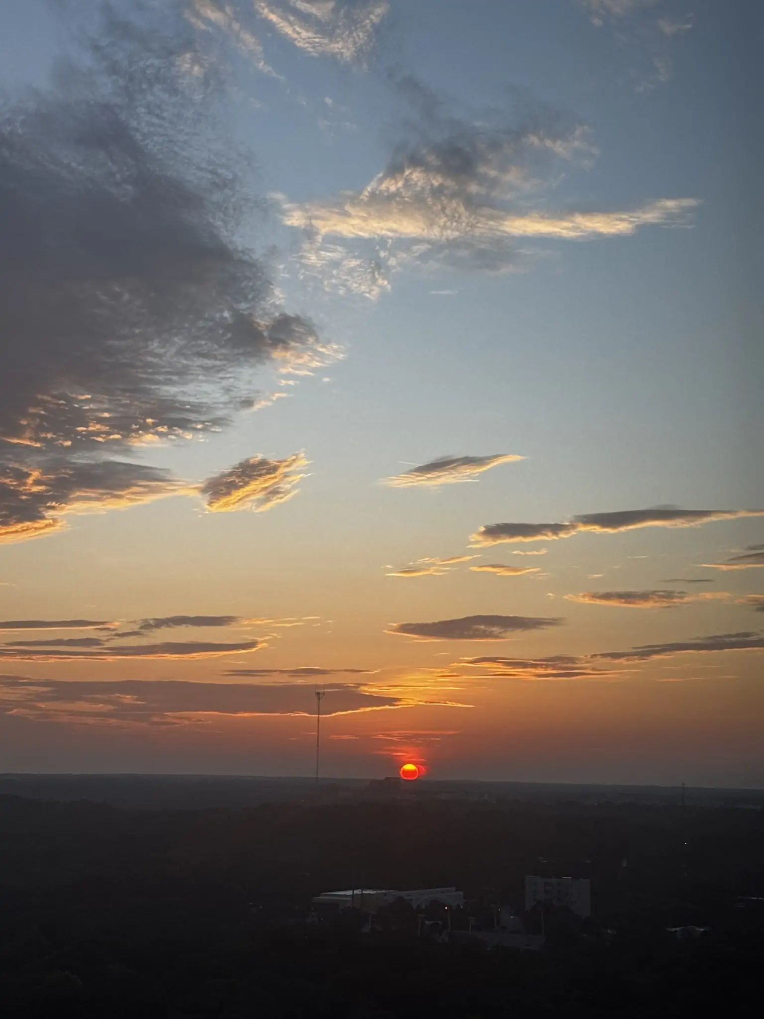 Stunning sunset with dramatic clouds and golden light over the horizon