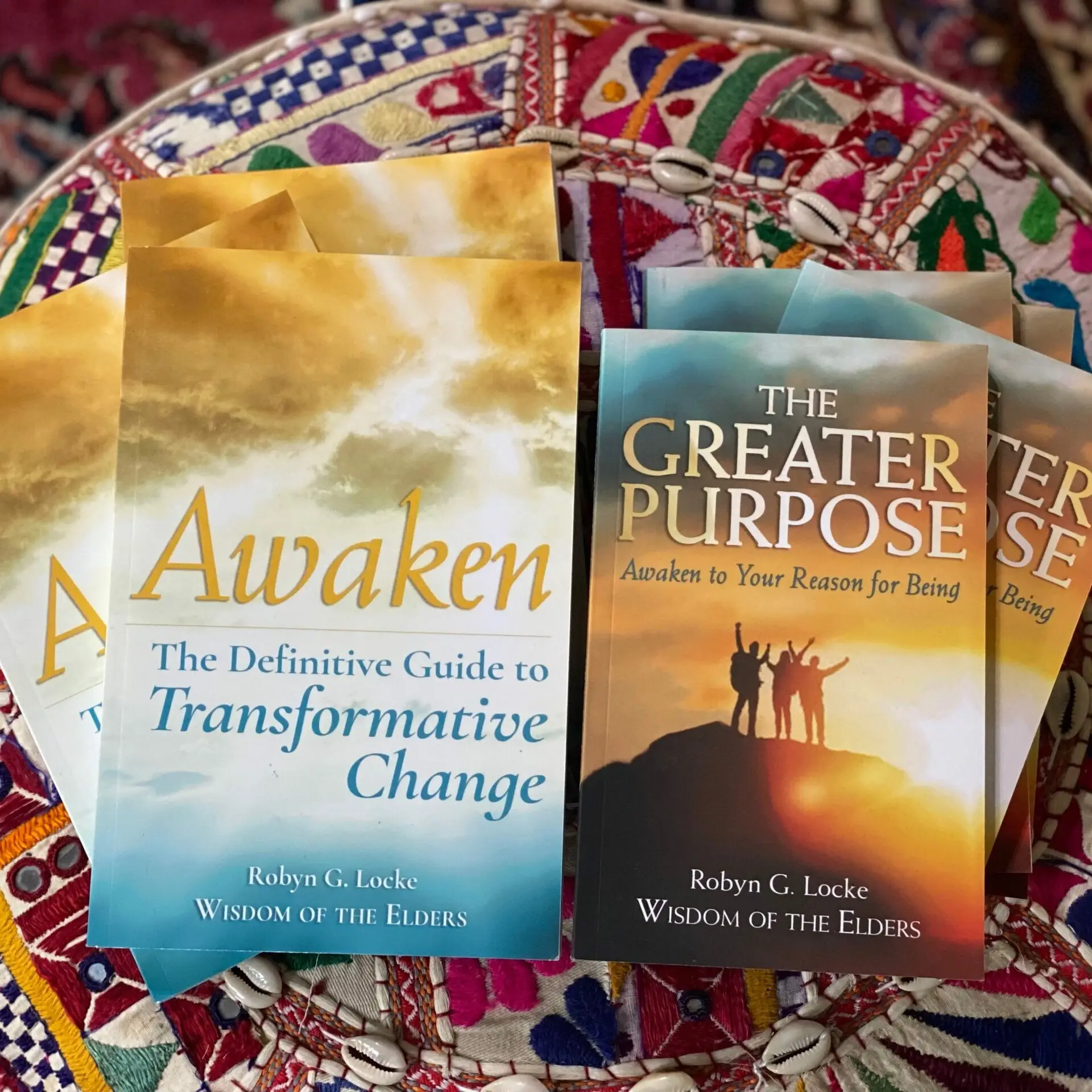 Awaken and The Greater Purpose books by Robyn G. Locke displayed on colorful fabric